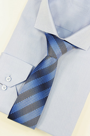 Blue shirt and striped tie on a white backgroundの写真素材