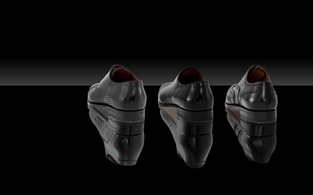 Three men's leather shoes sit with back on a dark backgroundの写真素材