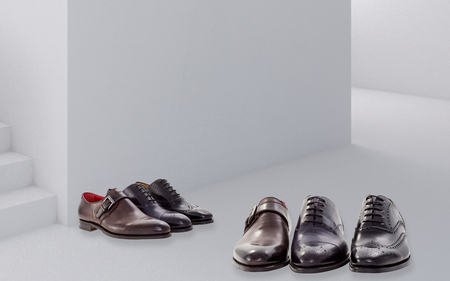 Three men's leather shoes sit on a greey backgroundの写真素材
