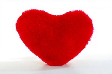Soft red heart pillow isolated on white backgroundの写真素材
