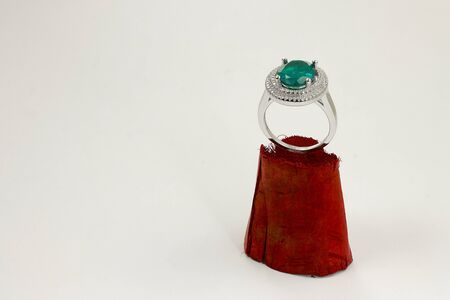 Emerald ring with diamonds put on wooden pedestalの写真素材
