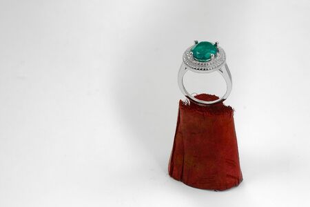 Emerald ring with diamonds put on wooden pedestalの写真素材