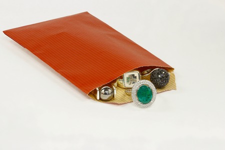 Silver and golden rings with different stones in red envelopeの写真素材