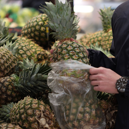 A seller who chooses pineapple in the storeの写真素材