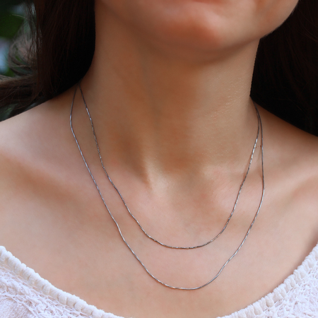 Silver chain at the neck of a womanの写真素材