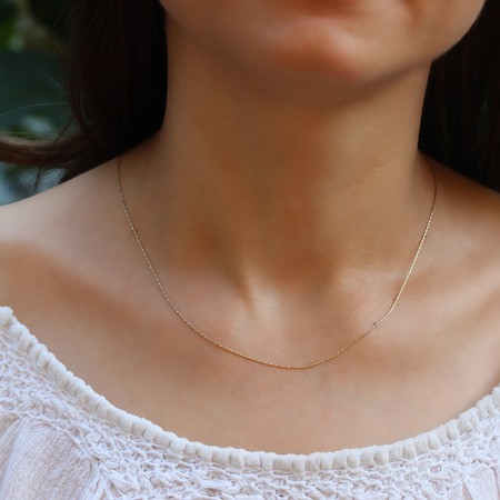 Silver chain at the neck of a womanの写真素材