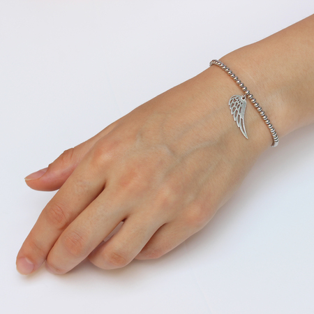 A woman's hand with silver bracelet with a lucky charmの写真素材