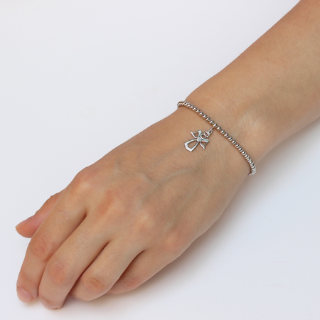A woman's hand with silver bracelet with a lucky charmの写真素材