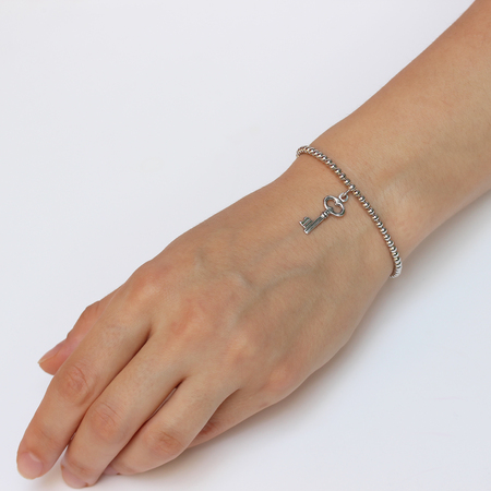 A woman's hand with silver bracelet with a lucky charmの写真素材