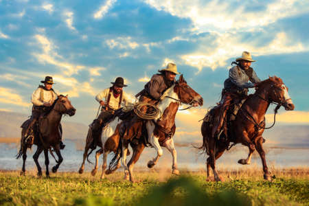 Cowboy riding a horse carrying a gunの写真素材