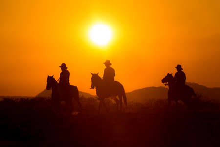 Cowboy silhouette riding a horse When the sunset looks beautifulの写真素材