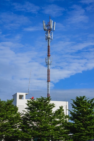 Broadcast Tower on white building with blue skyの写真素材