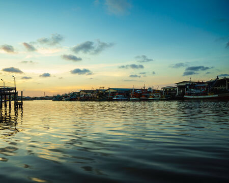 fish boats resting after hard work during sunsetの写真素材