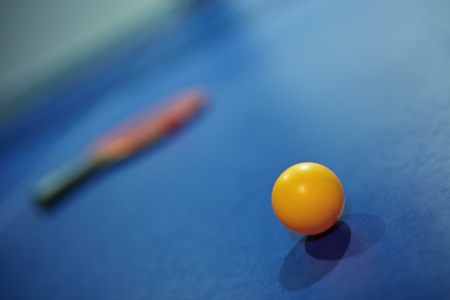 Image of a table tennis  ping pong  ball with bat at background 