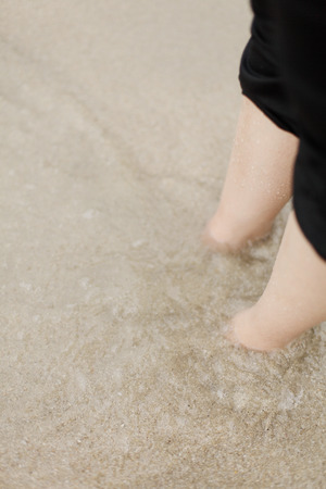 Legs in sandy beach waterの写真素材