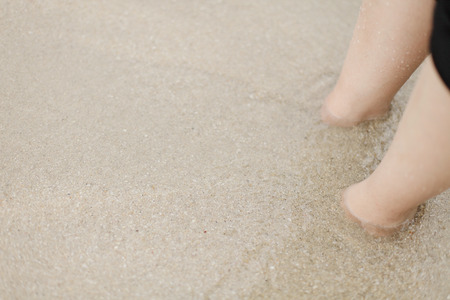 Legs in sandy beach waterの写真素材