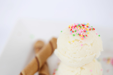 Vanilla ice cream scoop with confetti sprinkles on topの写真素材
