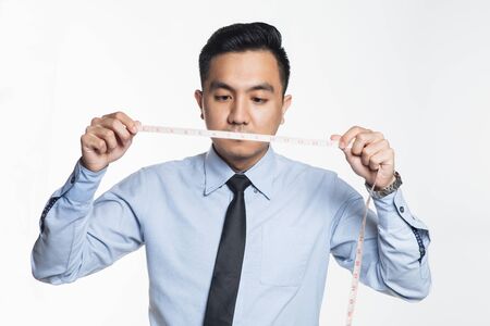 Asian business man holding a measurement tape.