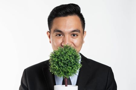 Man in suit holding a potted plant