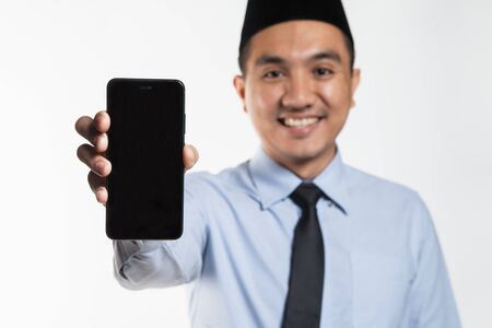 Asian male with songkok showing phoneの写真素材