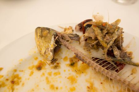 Eaten fish with head on a plate