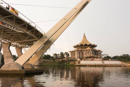 Kuching, Sarawak, Malaysia - September 2018: The Darul Hana bridge with new Sarawak State Assembly building (Dewan Undangan Negeri) with its distinctive "payung" (umbrella) roof is the state parliament of Sarawak.のeditorial素材