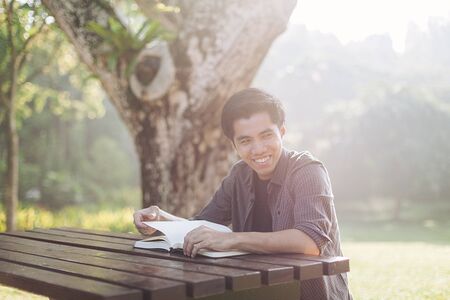 Young man studying alone at a parkの写真素材