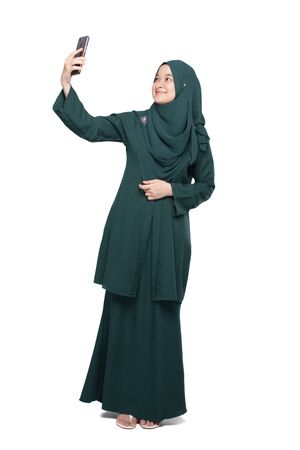 Malay woman taking selfie using smartphoneの写真素材