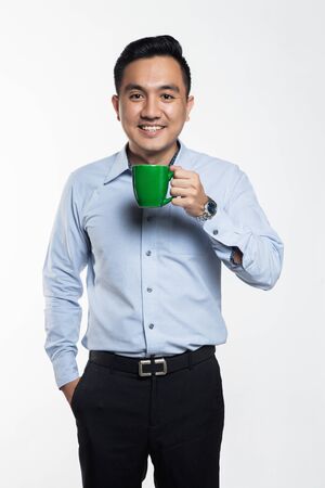 Good looking asian man holding a coffee mugの写真素材