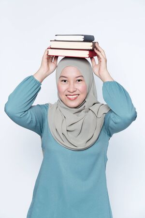 Woman putting books on top of her head.の写真素材