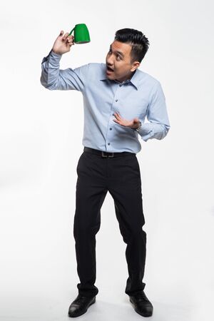 Good looking asian man holding a coffee mugの写真素材