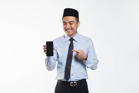 Asian male with songkok showing phoneの写真素材