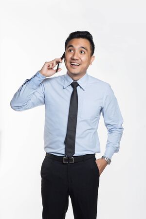Asian man in office wear using his phoneの写真素材