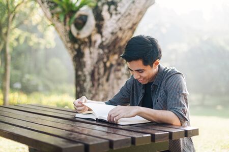 Young man studying alone at a parkの写真素材