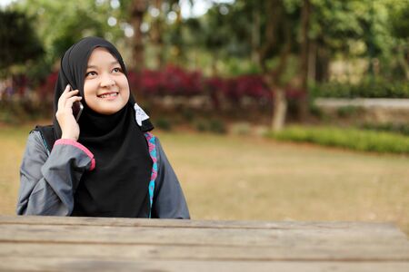 Muslim lady talking on the phone smilingの写真素材