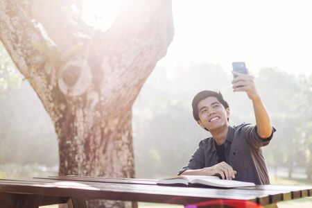 Young man taking selfie at a parkの写真素材