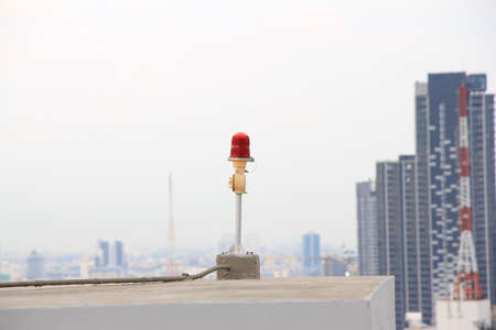 Red light on the roof with modern buildings in the background. Selective focus.の写真素材