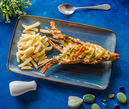 Grilled river prawns served with french fries on blue plate in high qualityの写真素材