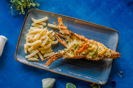 Grilled lobster served with french fries on blue plate, top view in high qualityの写真素材