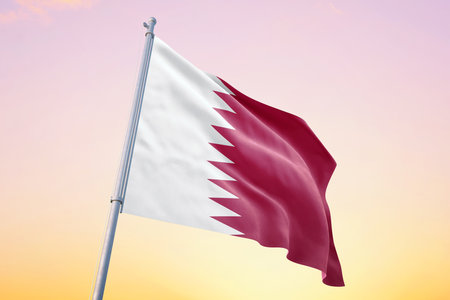 Qatar flag on flagpole waving on blue sky, sunset or sunrise background