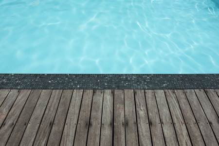 Blue swimming pool summer vacation and wooden deck
