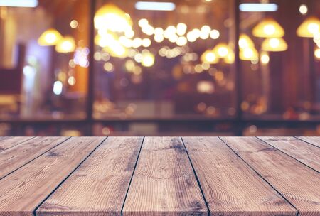 Wood table with blur light bokeh in night restaurant