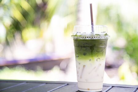 Iced matcha green tea mixed milk on wood tableの写真素材