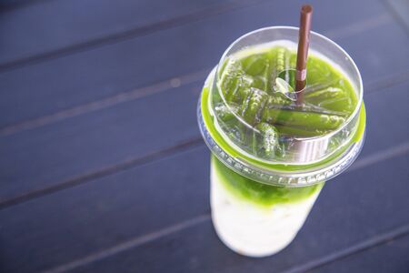 Iced matcha green tea mixed milk on wood tableの写真素材