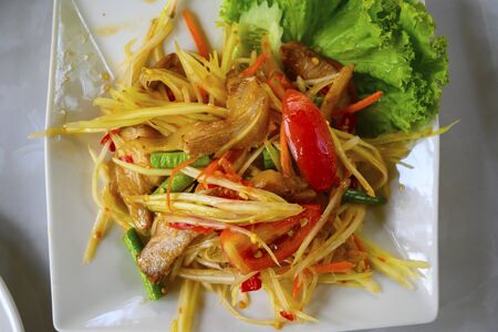 Papaya salad in a plate on a tableの写真素材