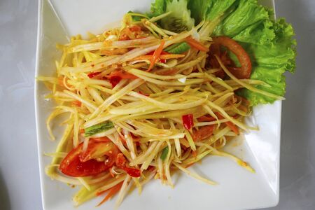 Papaya salad in a plate on a tableの写真素材