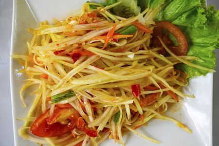 Papaya salad in a plate on a tableの写真素材