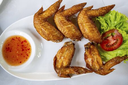 Fried chicken wings on a plate with dipping sauceの写真素材