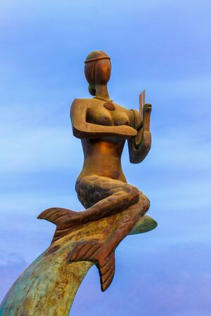 Mermaid made of cupper against the skyの写真素材