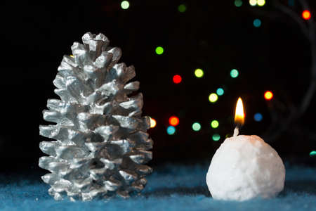 Christmas tree decotations: cone and candle against defocused lightsの写真素材